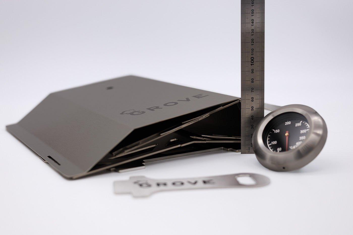 Produktfoto:
Horst der multifunktionale Campingofen in Einzelteilen gestapelt mit einem Lineal daneben, damit man sieht, dass die Verpackungshöhe nur 6,2cm beträgt