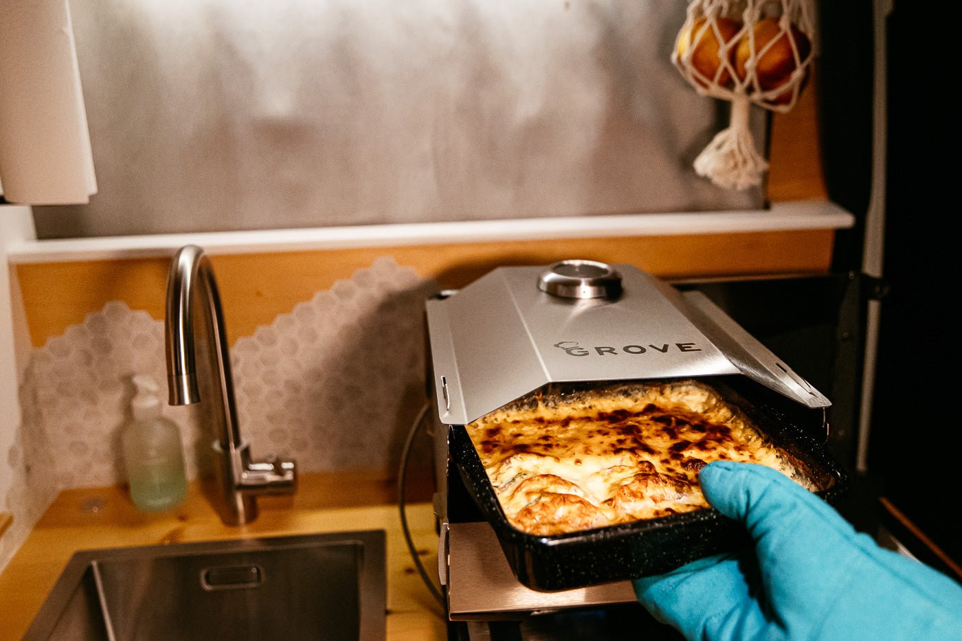 Ambientefoto:
Horst der multifunktionale Campingofen beim Auflauf backen mit Ofenhandschuh