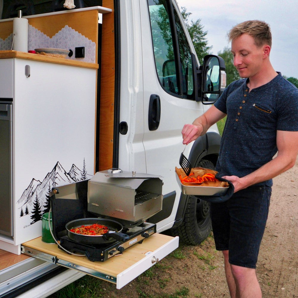 Grove Camping Gründer Fabian mit Horst Campingofen beim Essen zubereiten