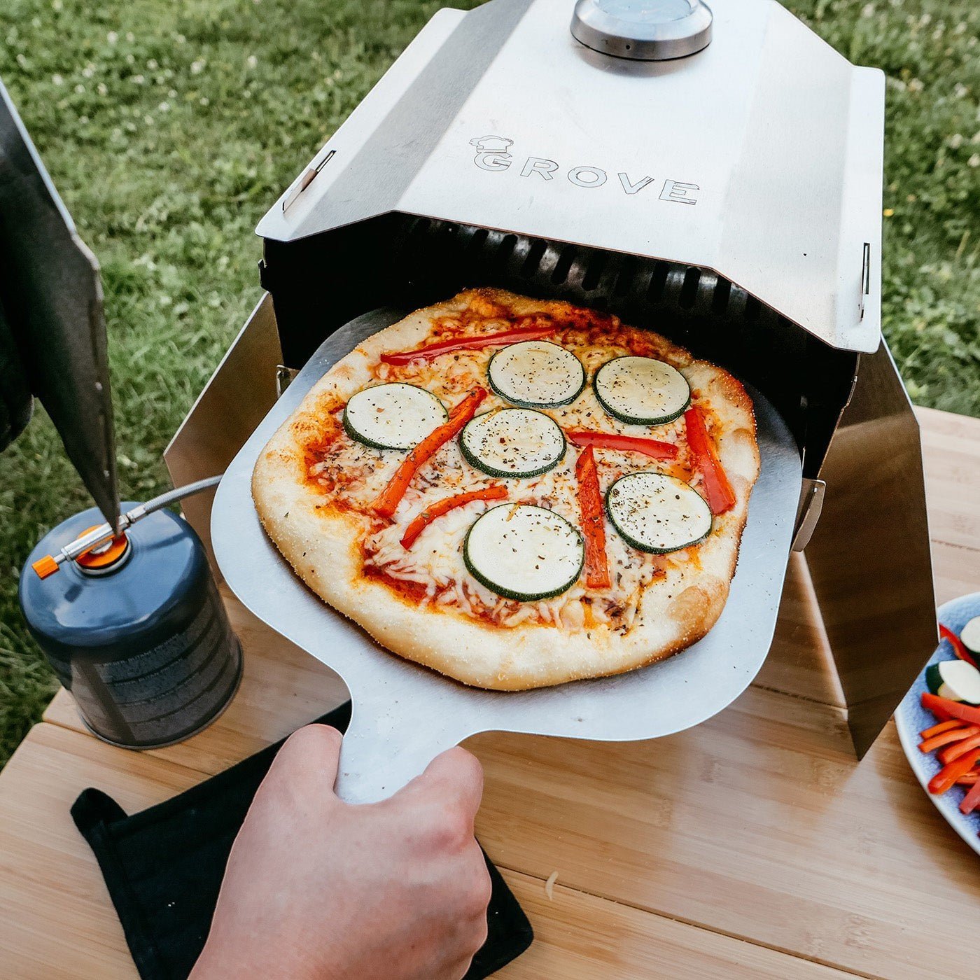 Ambiente:
Windschutz von Grove aufgestellt mit dem Campingofen Horst und einer fertig gebackenen Pizza