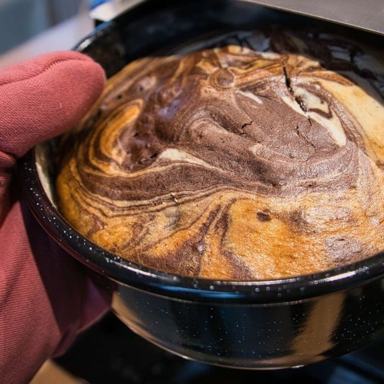 Ambientefoto:
Horst der multifunktionale Campingofen beim Backen eines Mamorkuchen in einer Emaille Tortenform