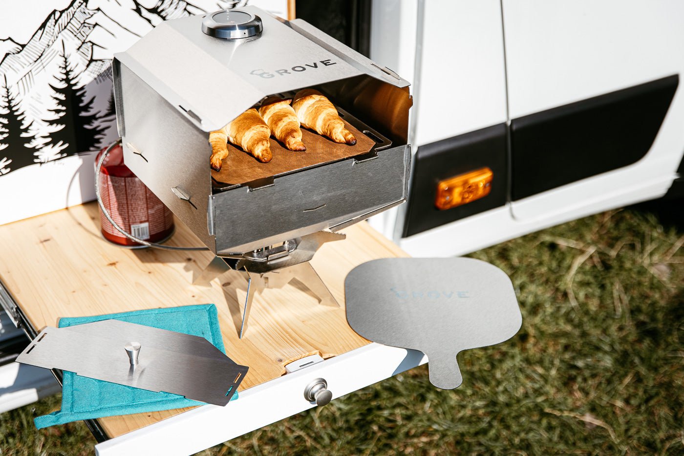 Horst Campingofen beim backen mit Topflappen türkis | Grove Camping