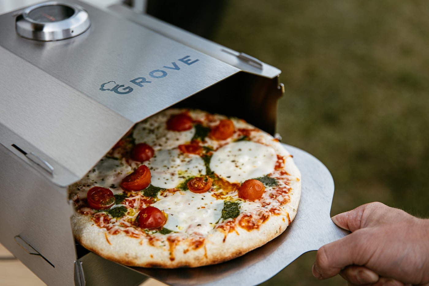 Grove Camping | Campingofen Horst mit Pizza auf dem Pizzaschieber