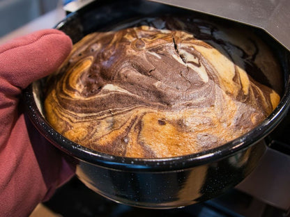Ambientefoto:
Horst der multifunktionale Campingofen beim Backen eines Mamorkuchen in einer Emaille Tortenform